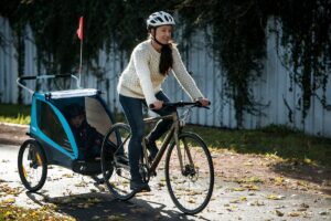 Thule Coaster XT fietskar Blauw moeder op de fiets met helm