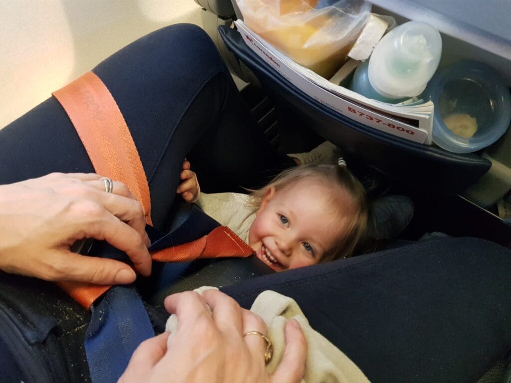 foto met kindje in het vliegtuig tussen benen van moeder