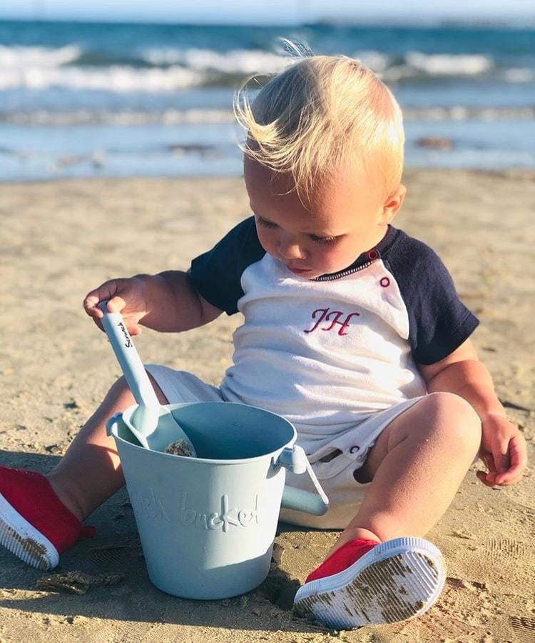 srunch emmer met schep jongen speelt op het strand