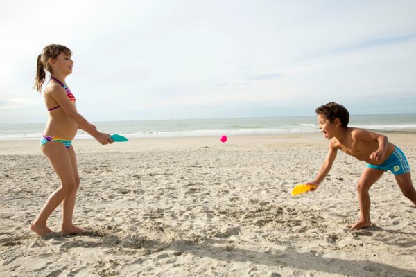 Quut-Cuppi-strandspeelgoed werpspel spelende kinderen op het strand