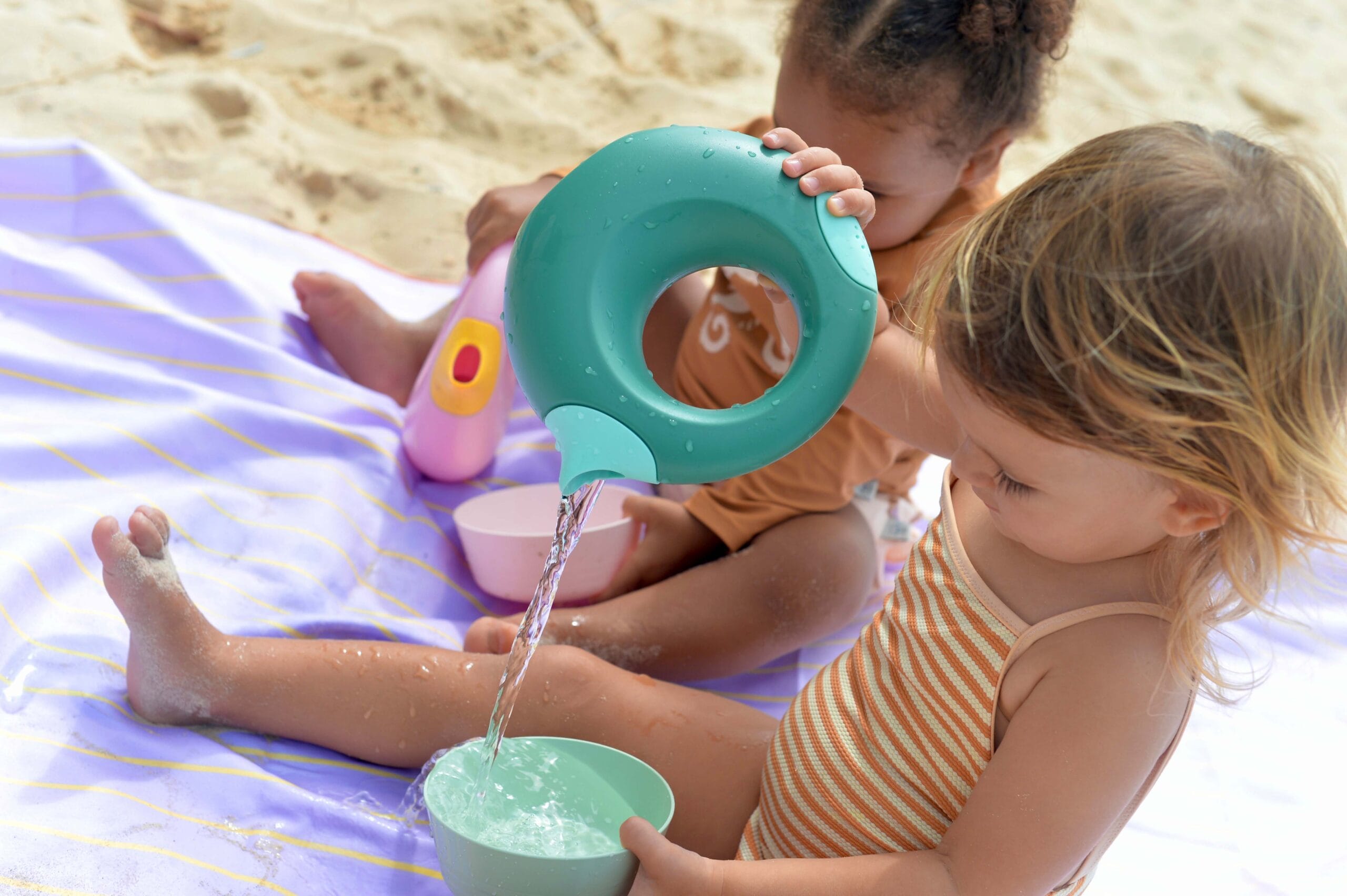 twee kinderen die spelen met een cana gieter op het strand van quut