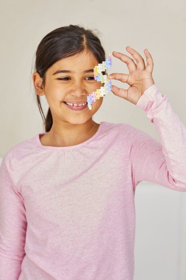 kind bouwt met plus plus pastel blokjes
