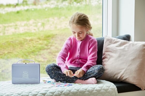 plus plus metalen opbergkoffer speelgoed kind speelt met plus plus mini bouwblokjes