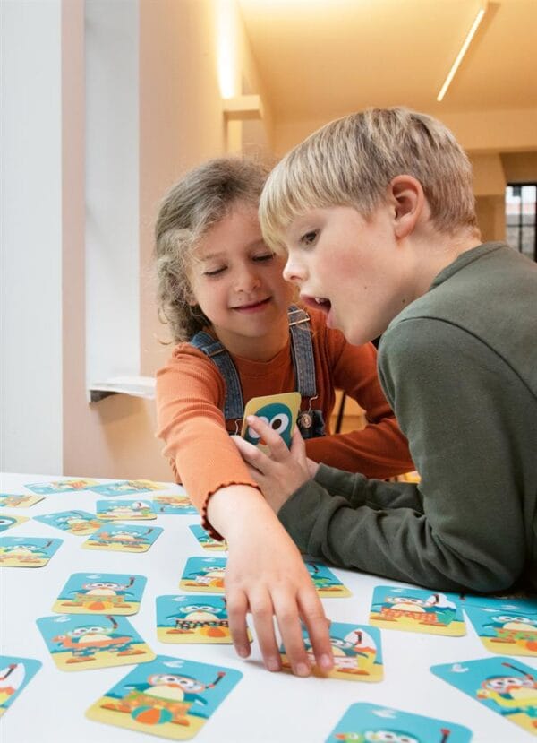 Kinderen spelen Penguin Match kaartspel onderweg