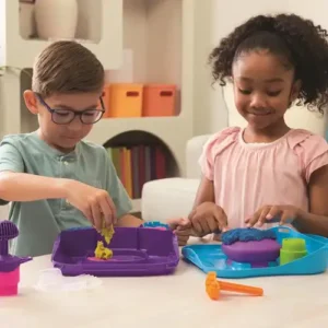 kind creëert laagjes met kinetic sand squish motion – stempel haai, zon en ster