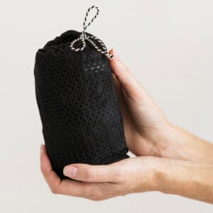 Minimonkey Mini Sling Zwart opgeborgen in het geïntegreerde opbergzakje